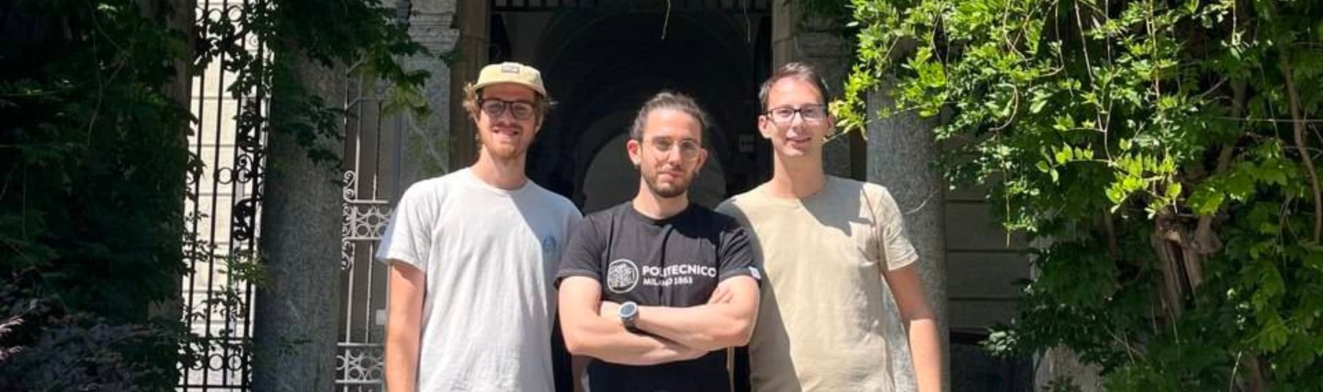 Three men standing in front a building.